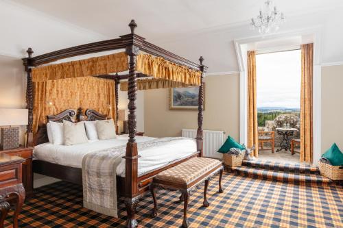 Tulloch Castle Hotel ‘A Bespoke Hotel’ في دينغول: غرفة نوم بها سرير بأربعة أعمدة ونافذة