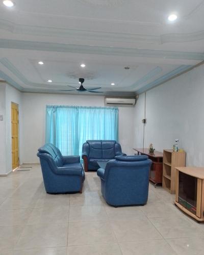 een woonkamer met twee blauwe stoelen en een tafel bij Welcome to Gemas Homestay ALI 