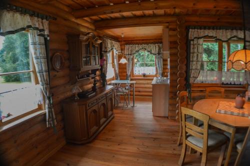 eine Küche und ein Esszimmer in einem Blockhaus in der Unterkunft Atpūtas namiņš ''Ievnieki'' in Kolka