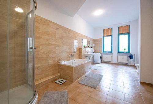 een grote badkamer met een bad en een wastafel bij Room&Go: Zentral - Terrasse - Weber Grill in Halle an der Saale
