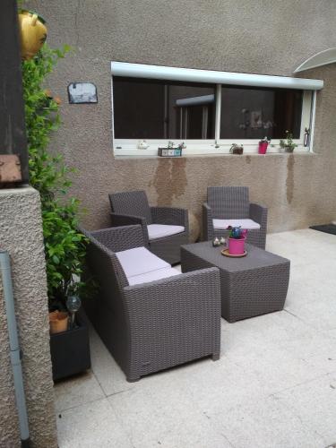 a patio with two chairs and a table and a window at Chambre un instant de cocooning 