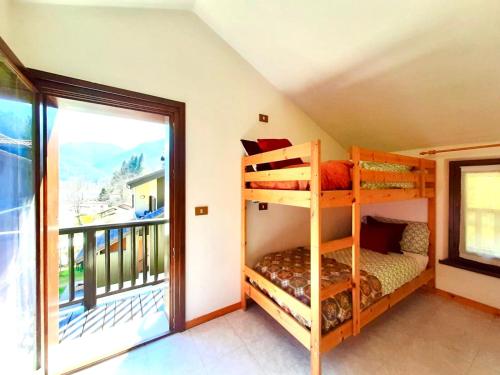 a bedroom with two bunk beds and a balcony at Casa Maria in Ledro