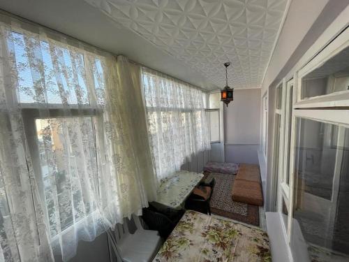a room with a window with curtains and a chair at Kumburgaz Sahilde, Sitede, Konforlu, Manzaralı Klimalı Daire in Buyukcekmece
