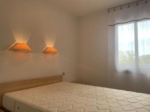 - une chambre avec un lit et deux lumières sur le mur dans l'établissement Juan les Pins: Appartement 2 pièces avec piscine proche plage - FR-1-252-194, à Antibes