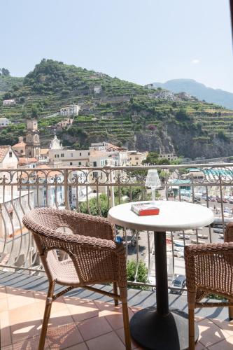 a table and chairs on a balcony with a view at Palazzo Vingius in Minori