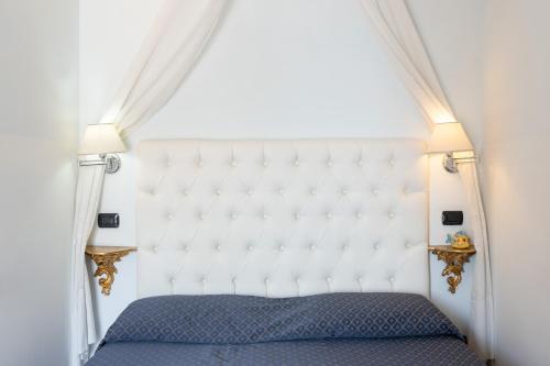 a bedroom with a large white bed with two lamps at Palazzo Vingius in Minori