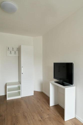 a living room with a flat screen tv on a white wall at Weinlandmotel in Ebenthal