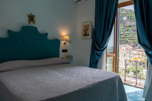 a bedroom with a bed and a large window at Palazzo Vingius in Minori