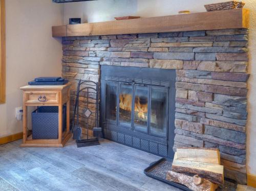 a living room with a stone fireplace with a fire at 2 2 Ferringway 9 in Durango