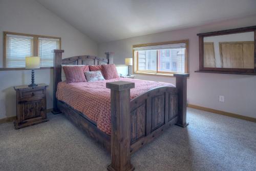 a bedroom with a wooden bed with pink pillows at 2 2 Ferringway 9 in Durango