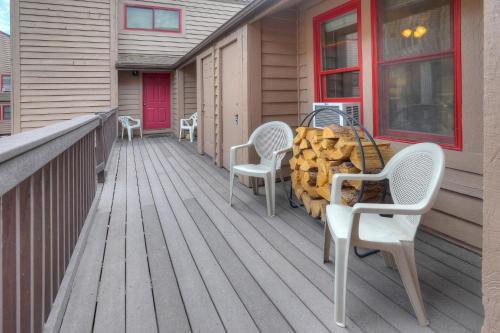 a deck with white chairs and a table with firewood at 2 2 Ferringway 9 in Durango