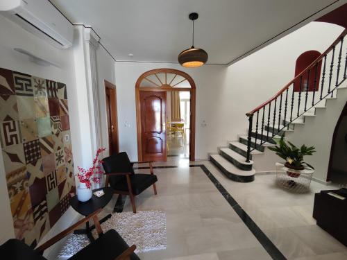 a living room with a staircase and a hallway at Balcón de la Villa in Priego de Córdoba