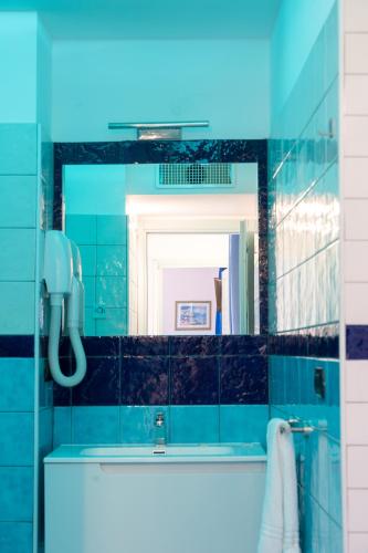 a blue bathroom with a sink and a mirror at Palazzo Vingius in Minori