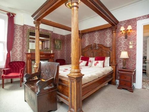 um quarto com uma cama de dossel e uma cadeira em Detached period house in sought after location em Torquay