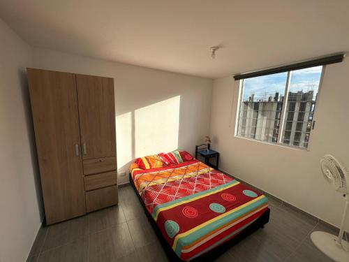 a small bedroom with a bed and a window at Apartamento Ricaurte in Ricaurte
