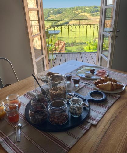 een tafel met een dienblad met eten op een tafel bij le secret du chat in Cordes-sur-Ciel
