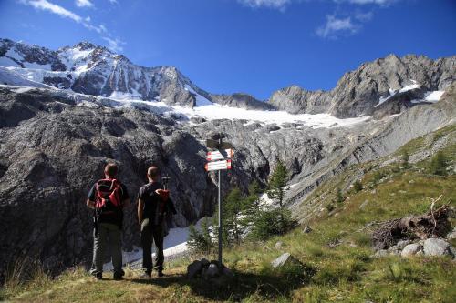 two people standing on a mountain looking at a glacier at ValmalencoAlpina in Caspoggio