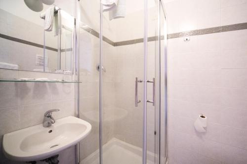 uma casa de banho com um lavatório e uma cabina de duche em vidro. em Hotel Nella em Florença