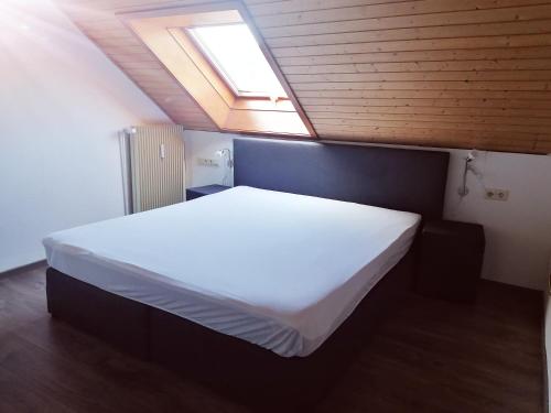 a bedroom with a large white bed with a skylight at Haus Schwarzwaldblick in Hornberg