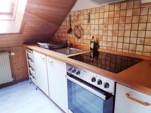 a kitchen with a sink and a stove at Haus Schwarzwaldblick in Hornberg