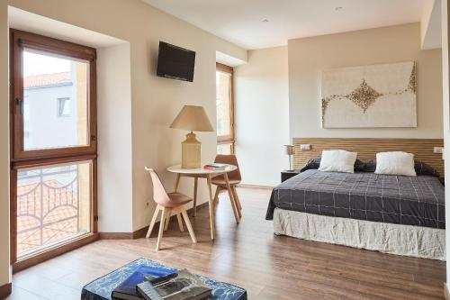 a bedroom with a bed and a table with a chair at Lagares de Riooja-Briñas in Briñas