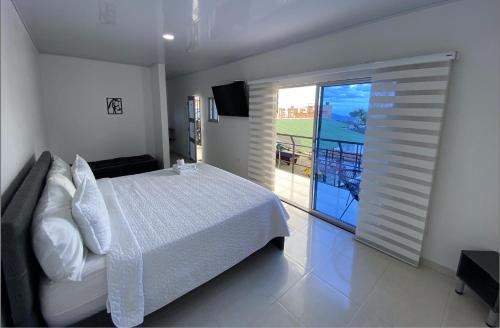 富薩加蘇加的住宿－HOTEL BELLA PAMPA FUSAGASUGA，卧室设有白色的床和大窗户