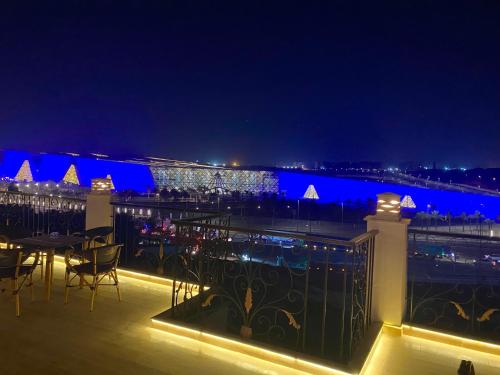 a balcony with tables and chairs at night at New Museum Guest House, Pyramids View in Cairo