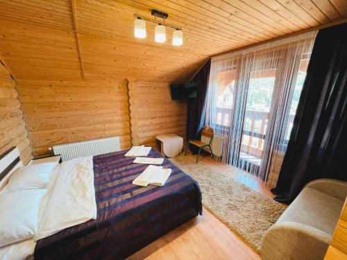 a bedroom with a bed and a large window at Готель Чарда in Bukovel