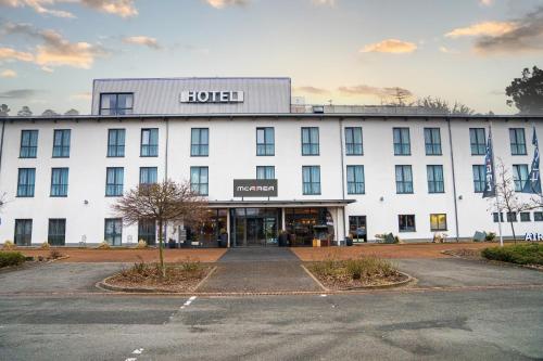 a large white building with a street in front of it at AiREA Hotel in Büren