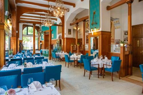 فندق باريس براغ في براغ: مطعم بطاولات بيضاء وكراسي زرقاء