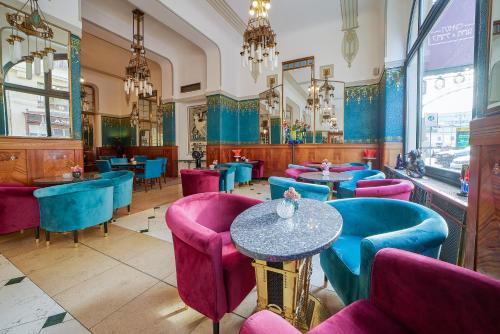 a restaurant with purple and blue chairs and tables at Hotel Paris Prague in Prague