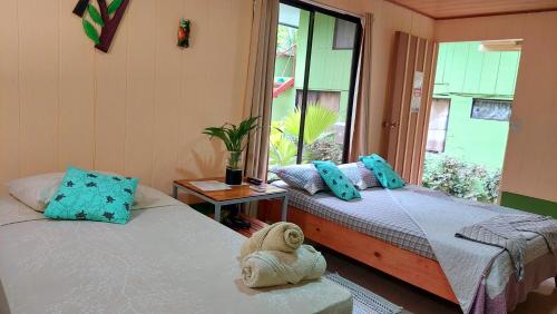 dwa łóżka w pokoju z oknem w obiekcie Casa el Tortugo w mieście Bahía Drake