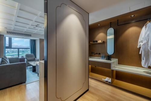 a hallway with a dressing room with a mirror at Huawen Four Season Hotel in Zhaoqing
