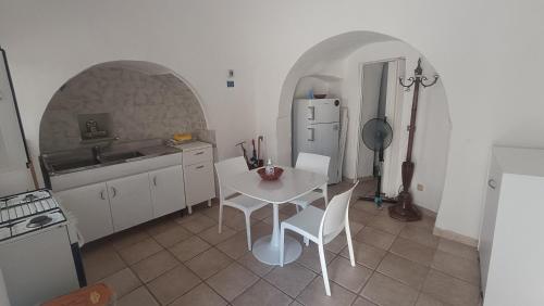 a kitchen with a white table and a white refrigerator at Trullo Alberobello Vacanze Desà 2 in Alberobello