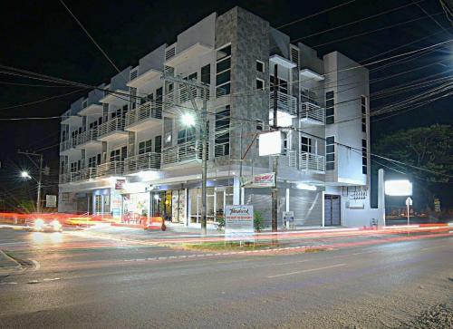 a building on a city street at night with traffic at Hardrock Residences in Cabanatuan