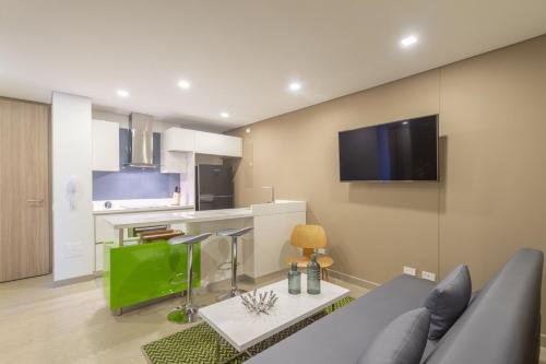 a living room with a couch and a kitchen at Apartamento moderno in Bogotá