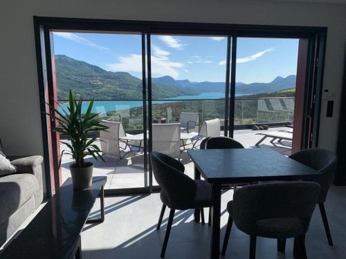 a room with a table and chairs on a balcony at Les Restanques du lac in La Chapelle
