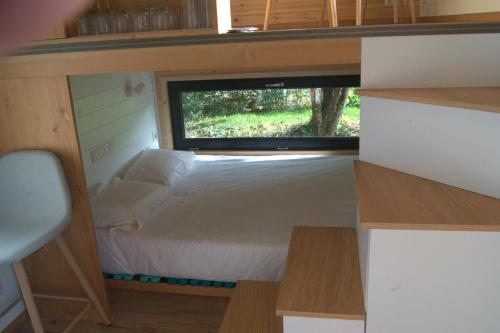 a bed in a tiny house with a window at Tiny Gaumaise - Tiny house à Saint-leger in Saint-Léger