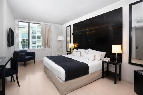 a hotel room with a large bed and a desk at Urbanica The Libertador Hotel in Buenos Aires
