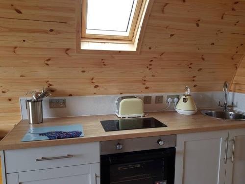 eine Küche mit einer Spüle und einer Arbeitsplatte in der Unterkunft Hoilisgeir Self Catering Pod in Daliburgh