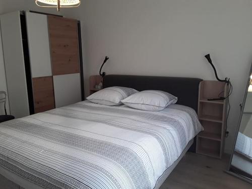 a bedroom with a large bed with two pillows at Confortable T2 NEUF - RDC - 2/4 personnes in Mondeville