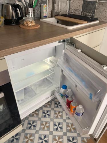 - un réfrigérateur ouvert avec une porte ouverte dans la cuisine dans l'établissement Montmartre Cosy, à Paris