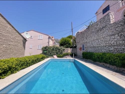 a swimming pool in a yard next to a building at Apartments Villa Marijeta with Free Parking in Zaton
