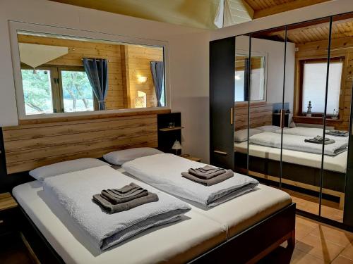 a bedroom with two beds with mirrors and towels at Ferienhaus Emsblick - a90188 in Walchum