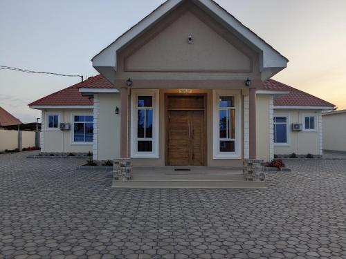 a house with a wooden door in a driveway at Mninga Classic Lodge, Ilazo in Dodoma