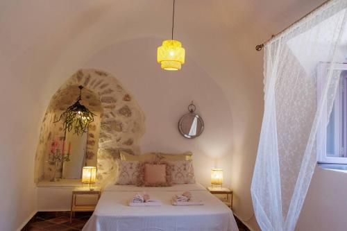 Iliana's house - spacious cave house in the center of Areopolis في أريوبوليس: غرفة نوم عليها سرير وفوط