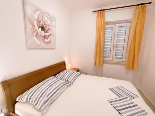 a bedroom with a bed and a window at Apartments Villa Marijeta with Free Parking in Zaton