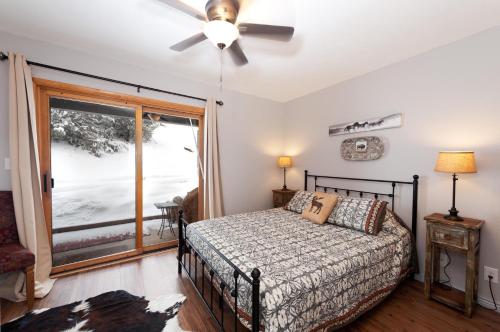 a bedroom with a bed with a ceiling fan and a window at Pine Acres - Unit 115 in Durango