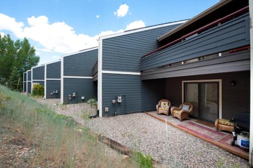 a house with two chairs sitting outside of it at Pine Acres - Unit 115 in Durango