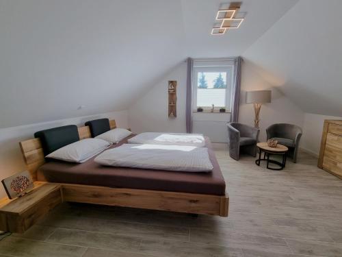 a bedroom with a large bed and a chair at WellnessOase Hafenblick - a90190 in Walchum